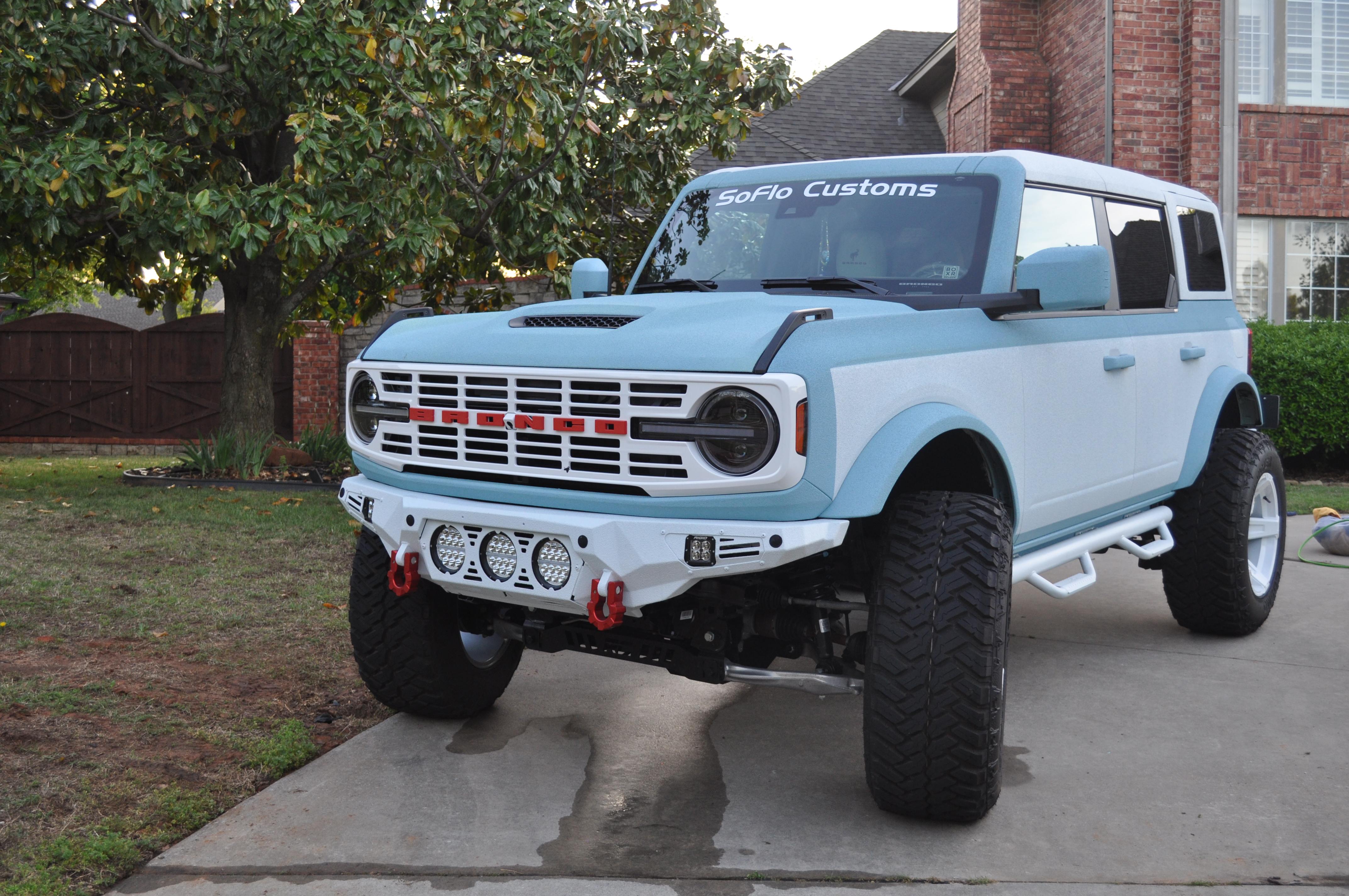 Custom lifted Ford Bronco with a light blue and white finish.